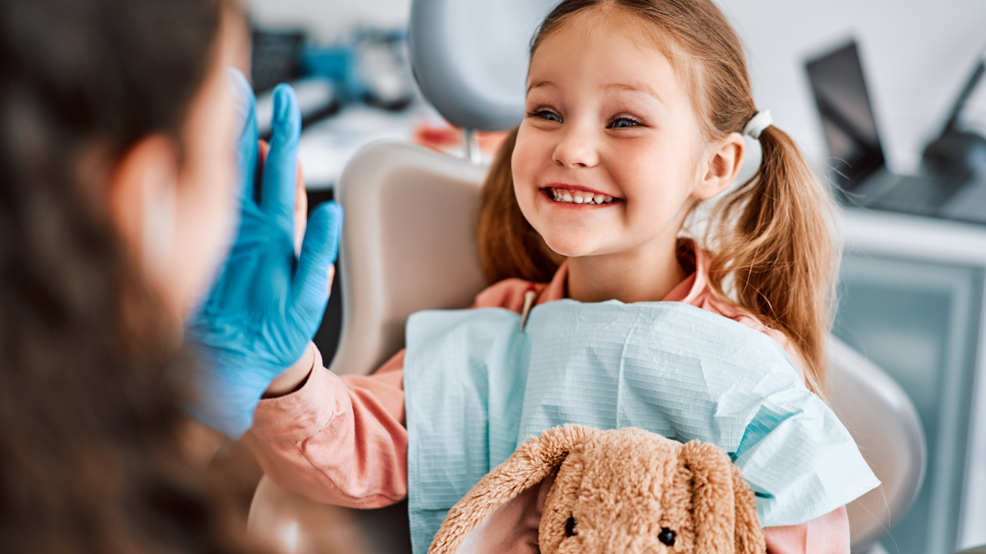 A happy child giving a high-five at the dentist